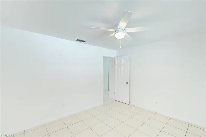 Tiled empty room with ceiling fan