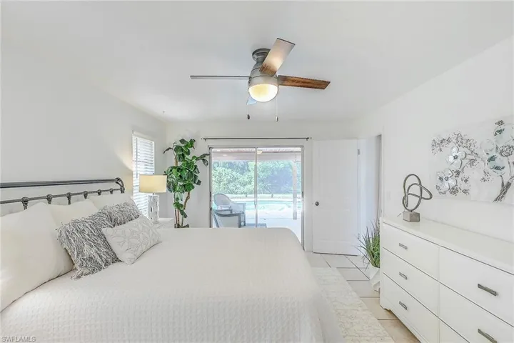 Tiled bedroom featuring ceiling fan and access to exterior