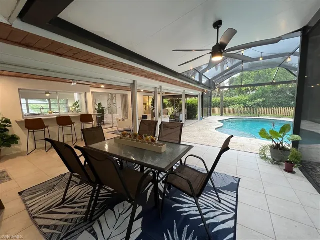 View of pool with a lanai, a patio area, and ceiling fan