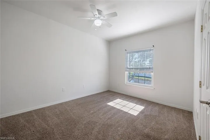 Carpeted empty room with ceiling fan