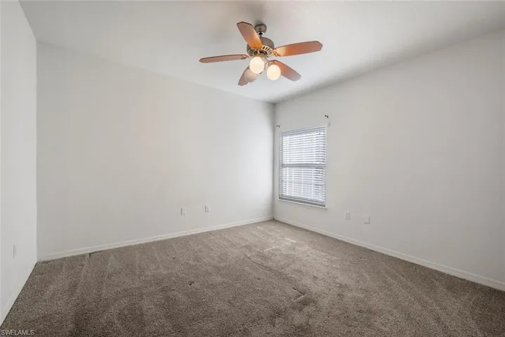 Carpeted spare room with ceiling fan
