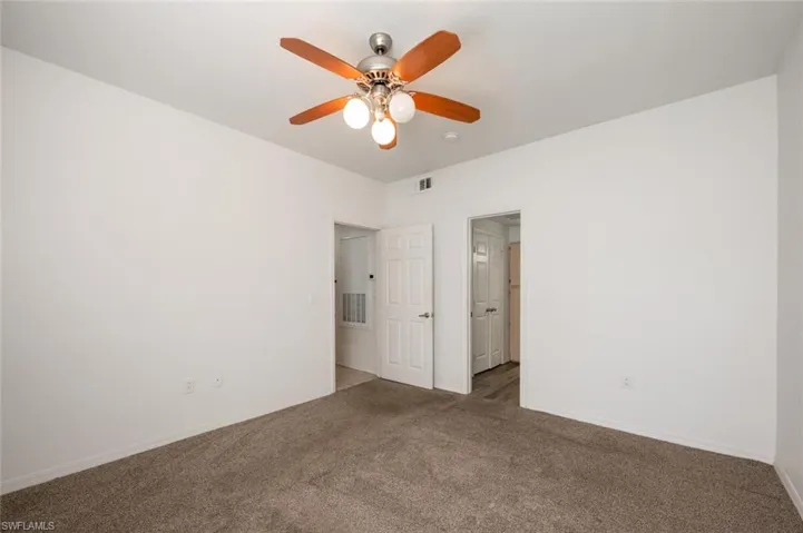 Carpeted empty room with ceiling fan