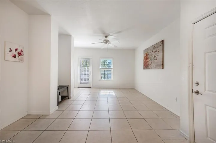 Tiled spare room featuring ceiling fan