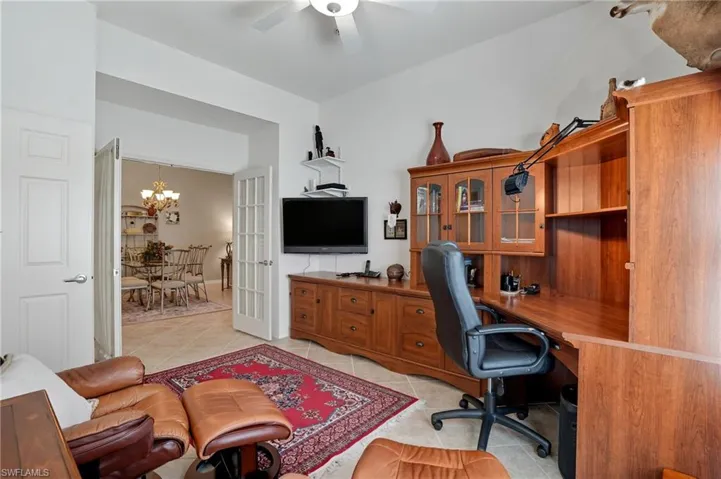 Office space with light tile patterned floors, a chandelier, a ceiling fan, and french doors