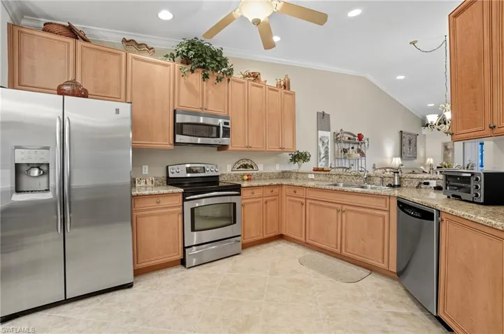 Kitchen featuring ornamental molding, stainless steel appliances, recessed lighting, light tile patterned floors, and ceiling fan