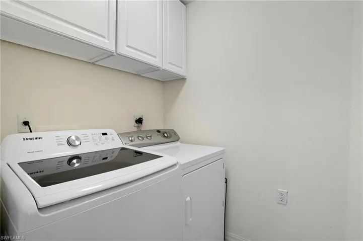 Washroom featuring cabinet space and washing machine and clothes dryer