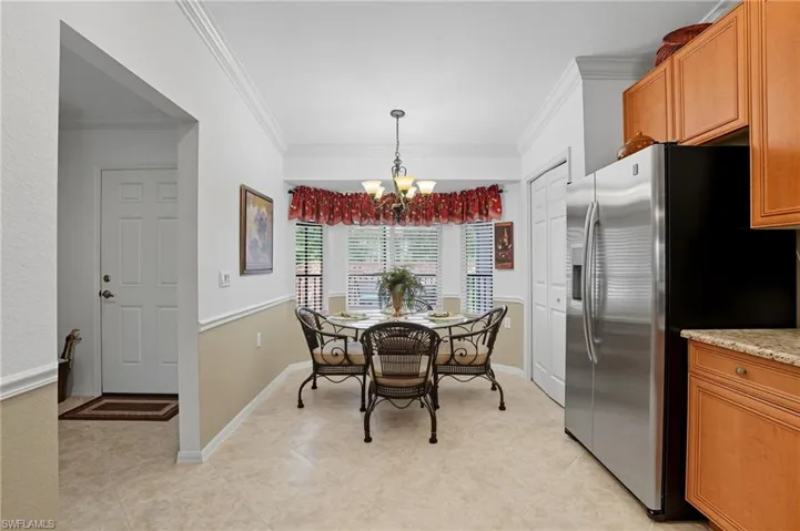 Dining space featuring a chandelier, crown molding, and light tile patterned floors