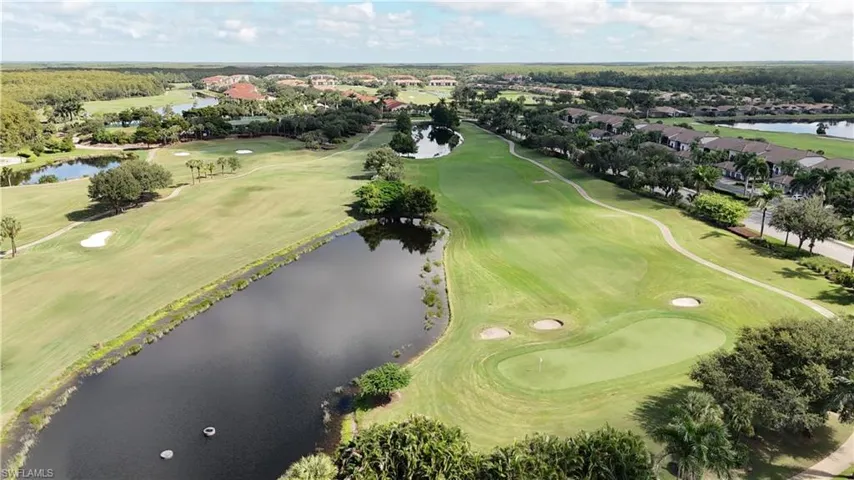 Aerial overview of property's location featuring a golf course and nearby suburban area