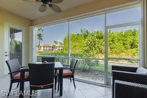 Screened patio featuring tile flooring and a ceiling fan
