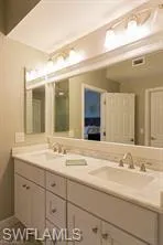 Dual sink vanity with white cabinetry and chrome hardware