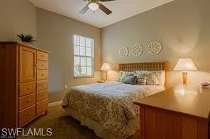 Vaulted ceiling with a ceiling fan, window with horizontal blinds, carpeted flooring, and a wooden headboard