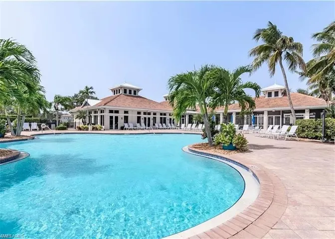 Expansive swimming pool with integrated spa and surrounding paver deck