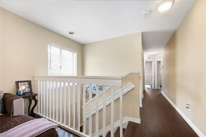 Hallway featuring dark wood finished floors and an upstairs landing