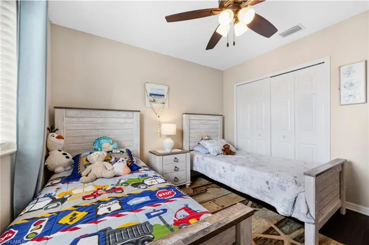 Bedroom with ceiling fan, a closet, and dark wood-style floors