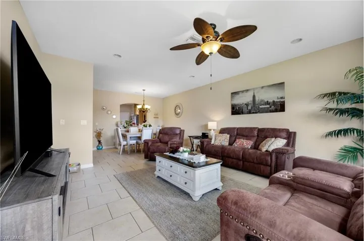 Living room with a chandelier, a ceiling fan, and light tile patterned floors