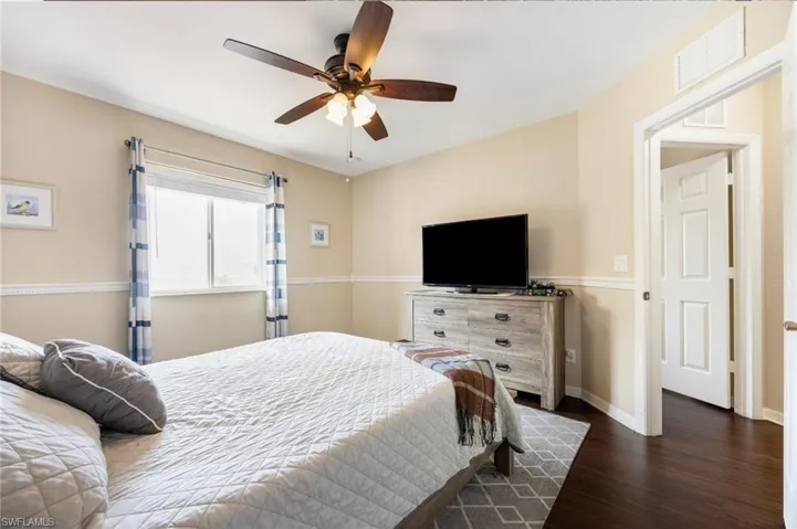Bedroom with dark wood-type flooring and a ceiling fan