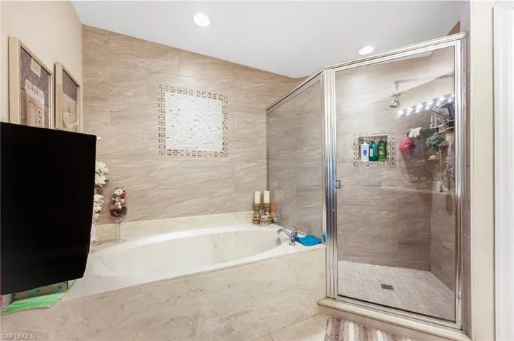 Full bathroom with a bath, a shower stall, tile walls, tile patterned flooring, and recessed lighting