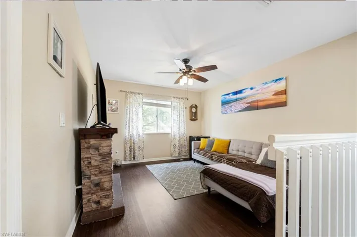 Bedroom with dark wood-style flooring and a ceiling fan