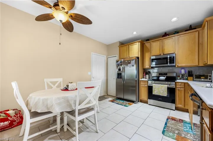Kitchen featuring stainless steel appliances, light countertops, tasteful backsplash, light tile patterned floors, and recessed lighting
