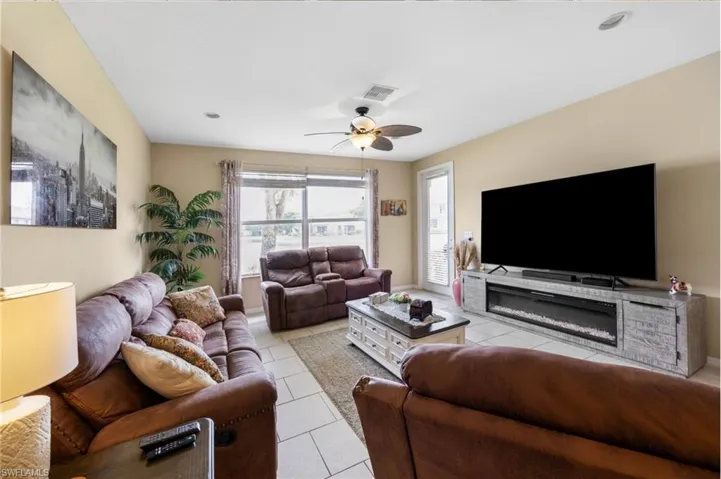 Living area featuring light tile patterned flooring and a ceiling fan