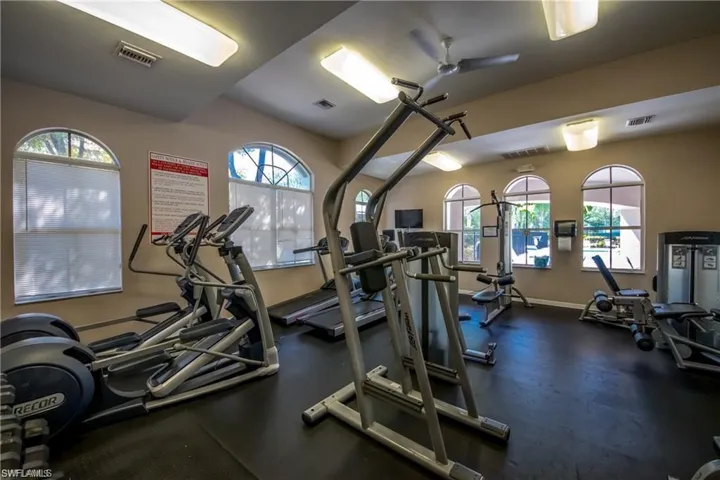 Exercise room featuring a ceiling fan and baseboards