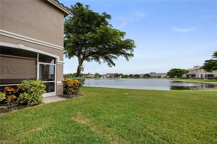 View of grassy yard featuring a water view and a sunroom