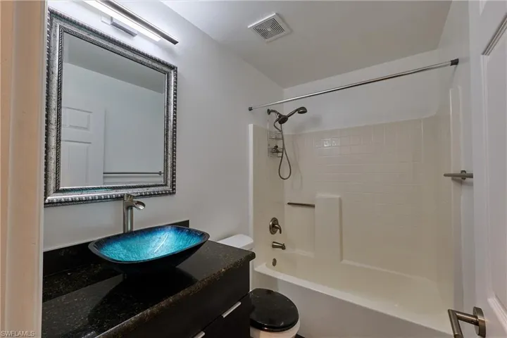 Full bath featuring vanity and washtub / shower combination