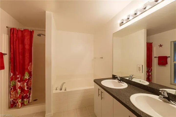 Full bath with a bath, double vanity, and a shower stall