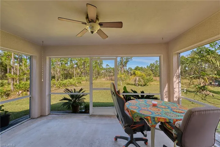 Sunroom / solarium with concrete flooring, healthy amount of natural light, and a textured wall