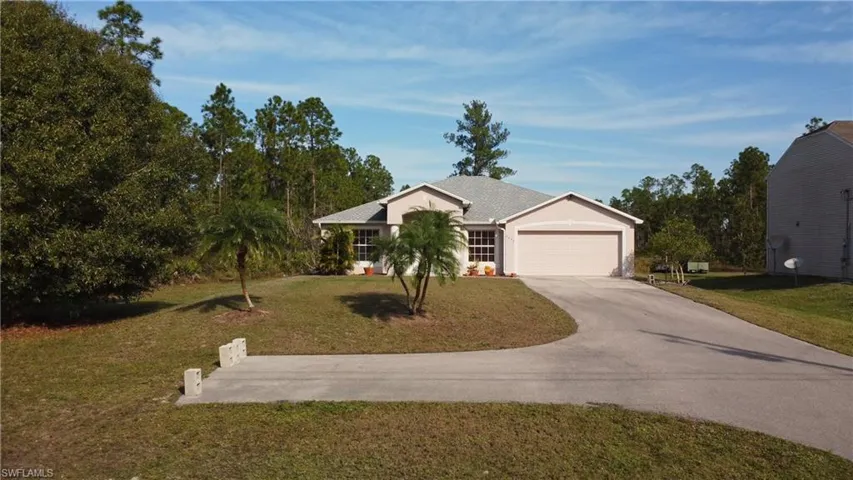Single story home featuring concrete driveway, a front lawn, a garage, and stucco siding