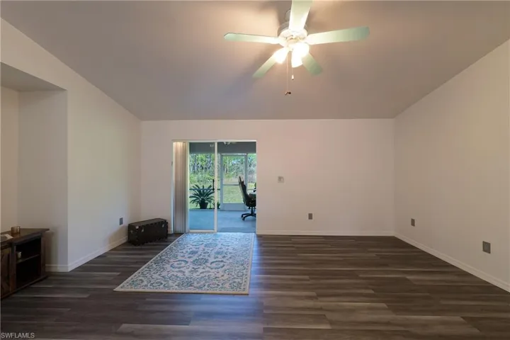 Unfurnished room with dark wood finished floors and a ceiling fan