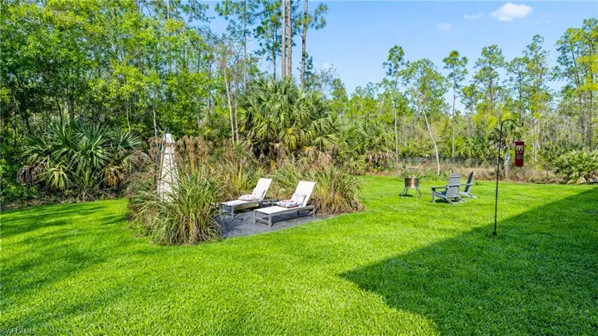 View of grassy yard featuring a patio