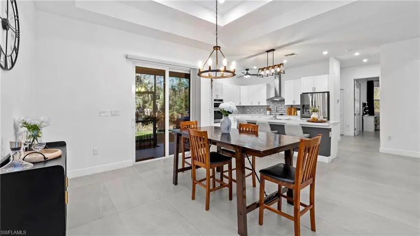 Dining area featuring plenty of natural light, hanging lights, and a raised ceiling