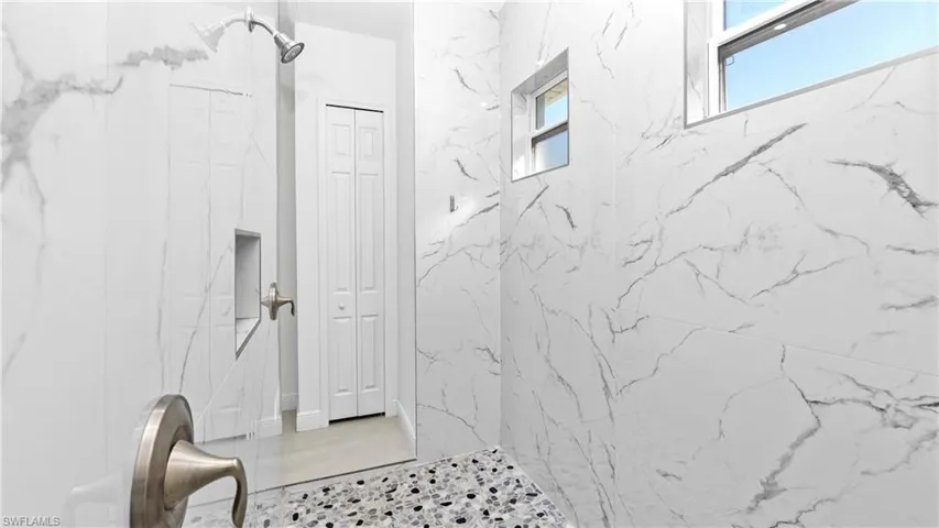 Full bath with a closet and a marble finish shower