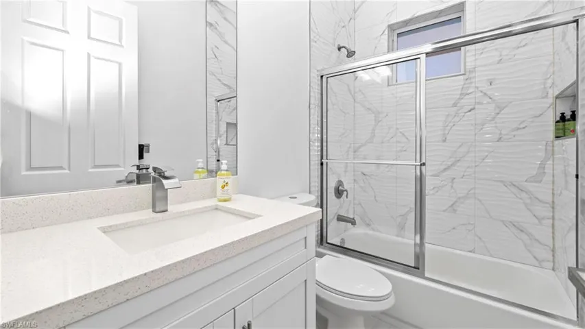 Full bath with enclosed tub / shower combo and vanity