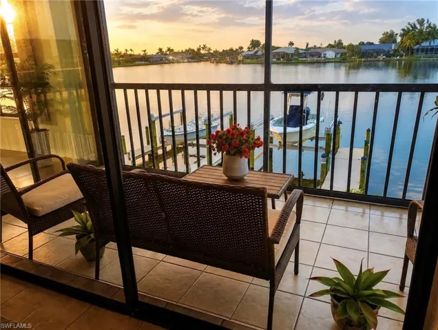 Screened lanai featuring tile flooring and waterfront access