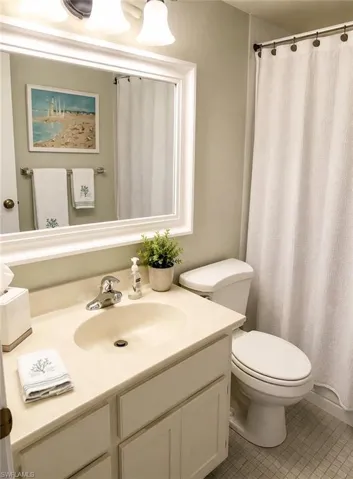 Bathroom featuring a vanity with an integrated sink, polished chrome faucet, and storage cabinetry