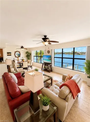 Open-concept living space featuring expansive windows, water views, and tile flooring