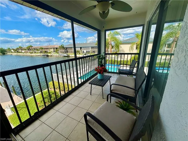 Screened balcony featuring tiled flooring, a ceiling fan, and sliding glass door access