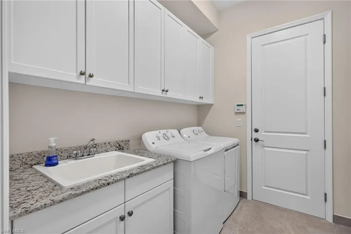 Laundry room with large utility tub, lots of cabinets for storage PLUS a whole opposite wall to make a mud room if you wish, or to install drying racks/folding table.