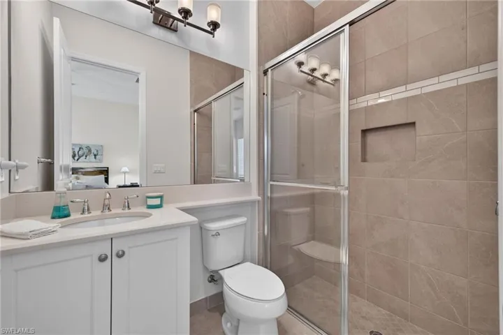 Ensuite bath to the 2nd bedroom, located to the left of the foyer.