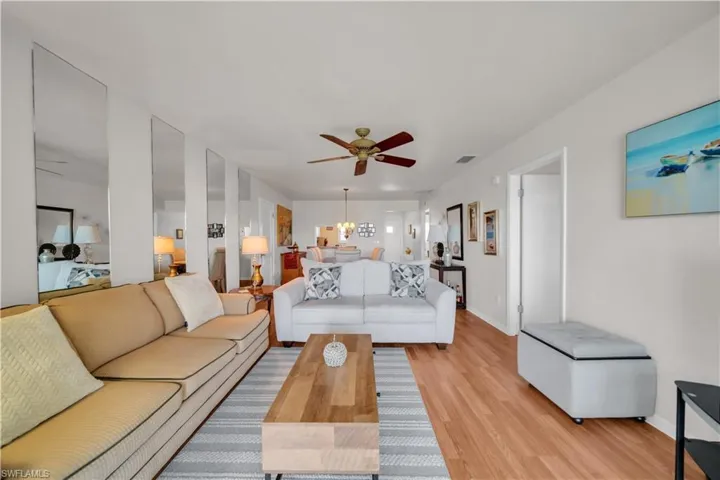 This inviting living area features hardwood flooring, a ceiling fan, and recessed lighting