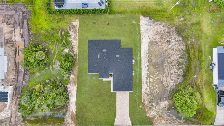 Aerial perspective featuring a rectangular residential lot, a paved driveway, and a shingled roofline