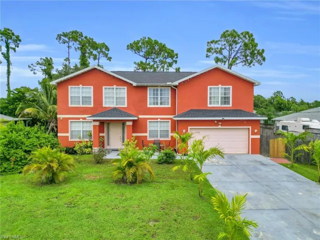 Traditional-style home with an attached garage, driveway, and stucco siding
