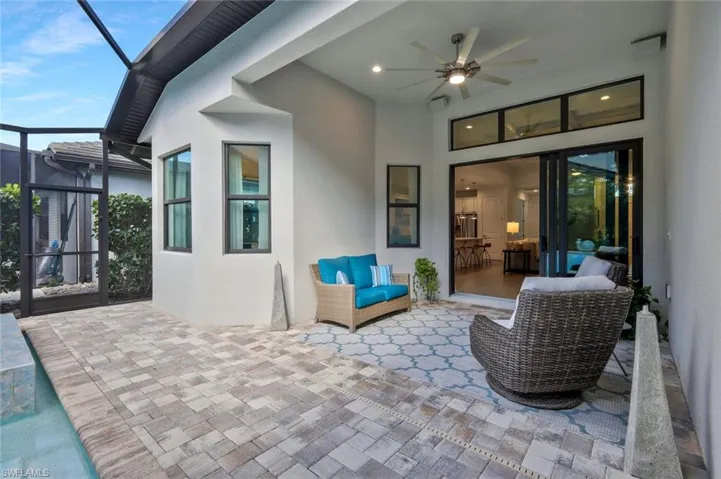 View of patio with glass enclosure and a ceiling fan