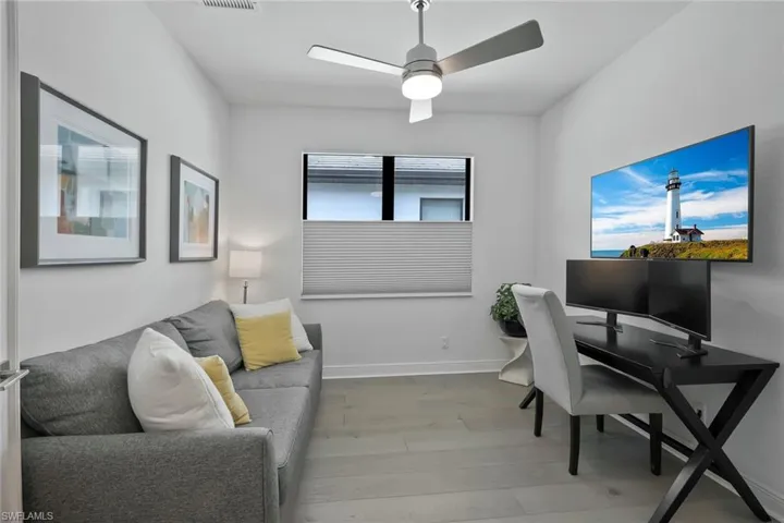 Office area featuring visible vents, baseboards, a ceiling fan, and wood finished floors