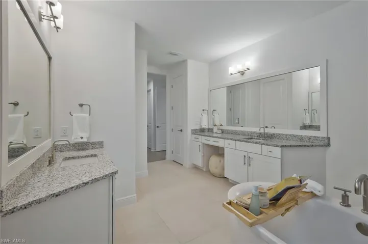 Full bath featuring a sink, visible vents, baseboards, and two vanities