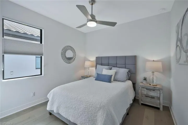 Bedroom featuring a ceiling fan, wood finished floors, and baseboards