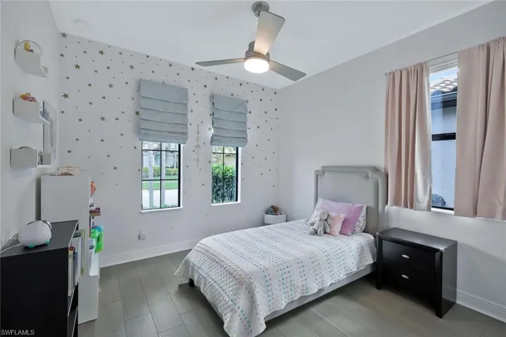 Bedroom featuring a ceiling fan, baseboards, and wood finished floors