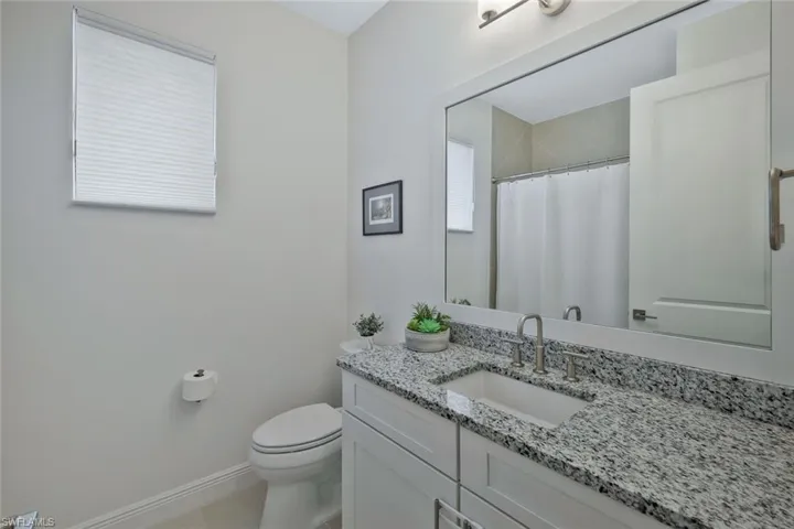 Full bathroom with a shower with shower curtain, toilet, vanity, and baseboards